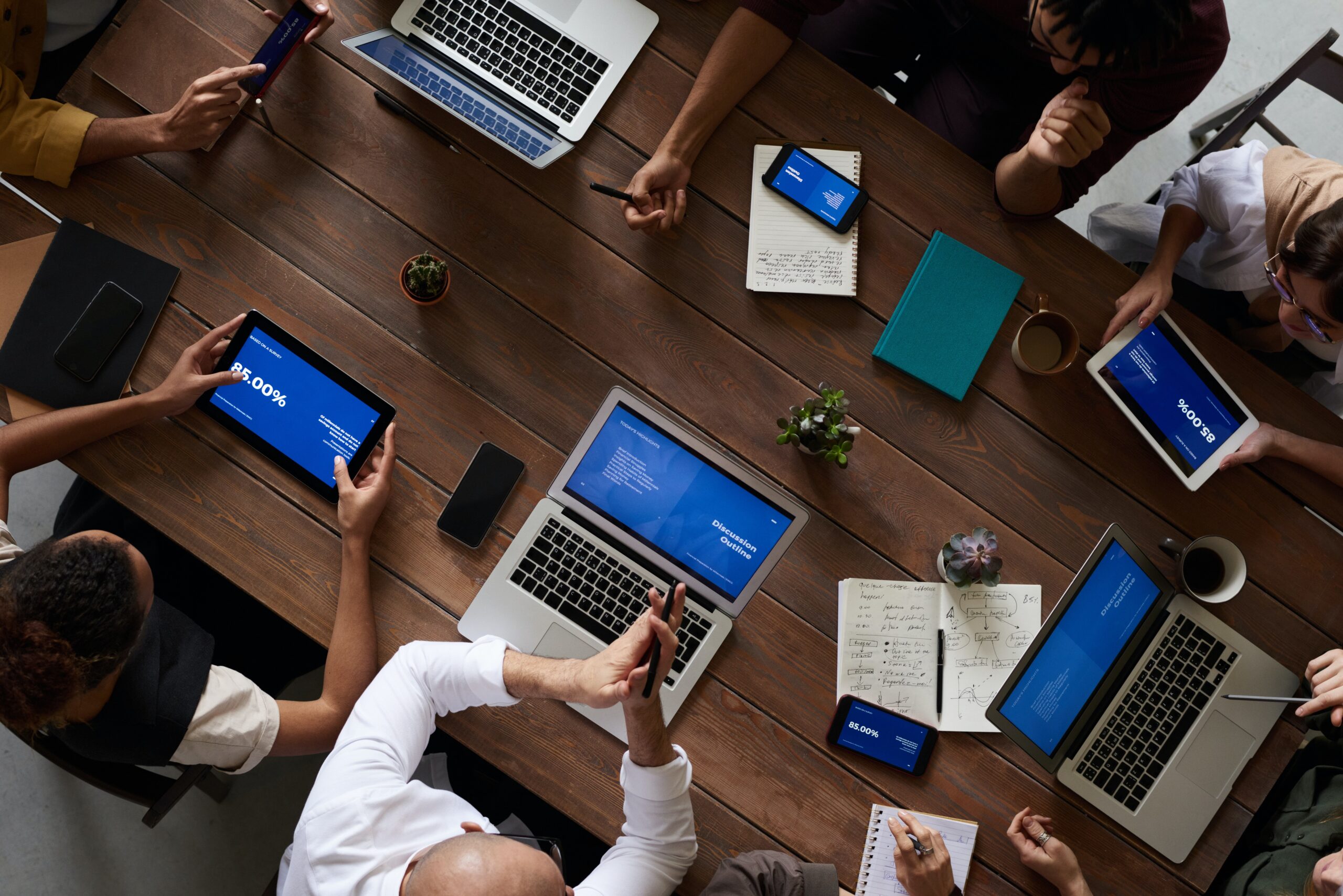 People with laptops sitting on the desk with one QA engineer